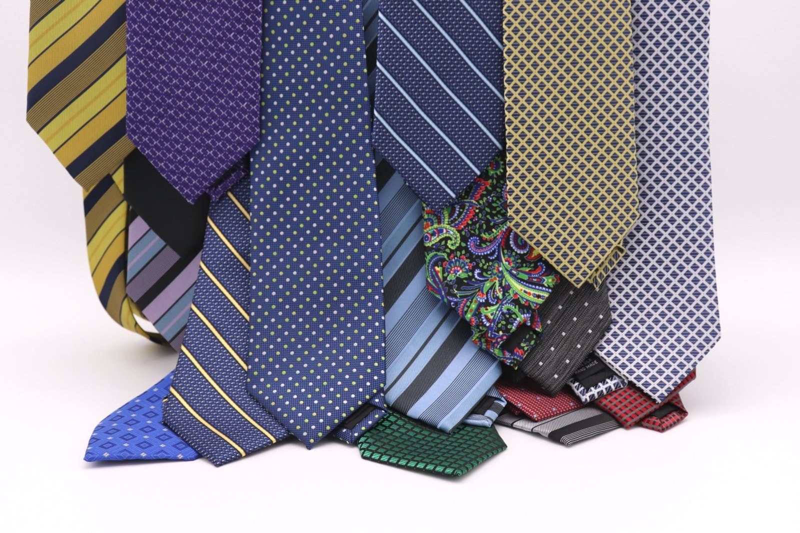 Multiple premium custom silk ties arranged elegantly in a fan layout, showcasing woven jacquard texture and silk shine